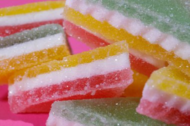 Pembe arka planda üçgen şeker yığını. Macro, seçici odaklanma.