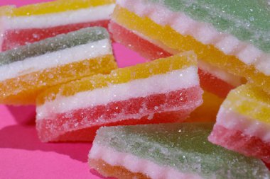 Pembe arka planda üçgen şeker yığını. Macro, seçici odaklanma.