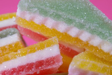 Pembe arka planda üçgen şeker yığını. Macro, seçici odaklanma.