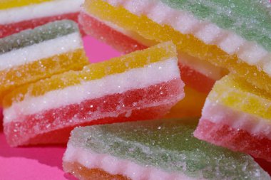 Pembe arka planda üçgen şeker yığını. Macro, seçici odaklanma.