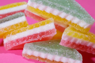 Pembe arka planda üçgen şeker yığını. Macro, seçici odaklanma.