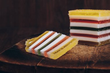 Ahşap masada dilimlenmiş çizgili marmelat. Renkli jöleli şekerler yakın plan..