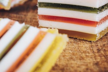 Ahşap masada çok renkli marmelatlar var. Renkli jöle şekerleri yakın plan. Makro çekim, seçici odaklanma.