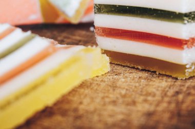 Ahşap masada çok renkli marmelatlar var. Renkli jöle şekerleri yakın plan. Makro çekim, seçici odaklanma.