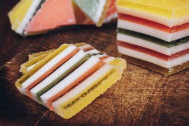 Ahşap masada dilimlenmiş çizgili marmelat. Renkli jöleli şekerler yakın plan..