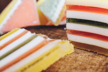 Ahşap masada çok renkli marmelatlar var. Renkli jöle şekerleri yakın plan. Makro çekim, seçici odaklanma.