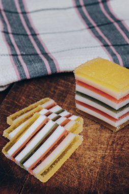 Ahşap masada dilimlenmiş çizgili marmelat. Renkli jöleli şekerler yakın plan..