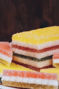 Ahşap arka planda renkli jöle şekeri. Çok renkli marmelatlı reçelli şekerler. Bir yığın üçgen ve dikdörtgen marmelat şekeri. Makro.