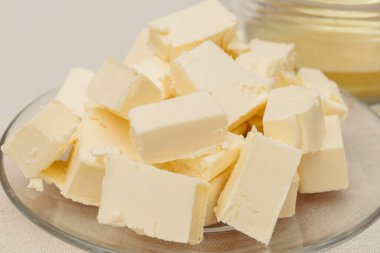 Cam kaplama üzerinde küp tereyağı parçaları. Makro atış. Seçici odak.