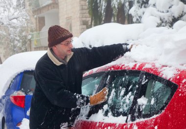 Man cleaning his car from snow clipart