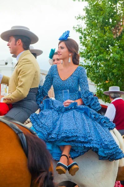 Mujer joven en un vestido azul a caballo — Foto de Stock