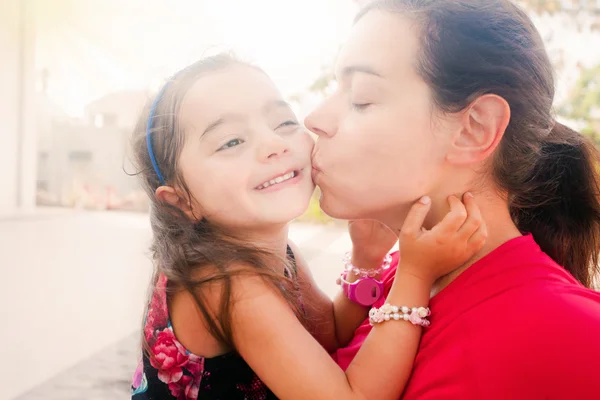 Young mother kissing her daughter — Stock Photo, Image