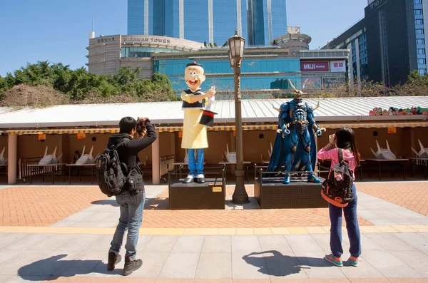 Turistas tirar fotos de personagens de desenhos animados asiáticos no parque da cidade — Fotografia de Stock