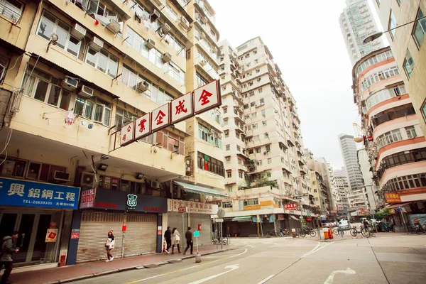 Hong Kong yüksek beton binalar ile sokakta yürürken insanlar.