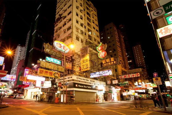 İnsanlar ve reklam panoları mağazaların yürüyen kalabalık gece çekimi — Stok fotoğraf
