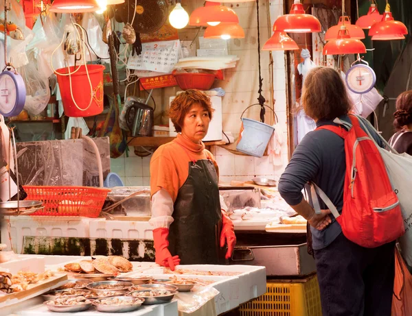 Händlerinnen des Fischmarktes verteilen Meeresfrüchte zum Verkauf auf einem Tablett auf der Straße — Stockfoto