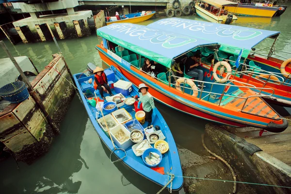 Coloridos barcos fluviales con vendedores de peces y algunos turistas de pueblo pesquero — Foto de Stock