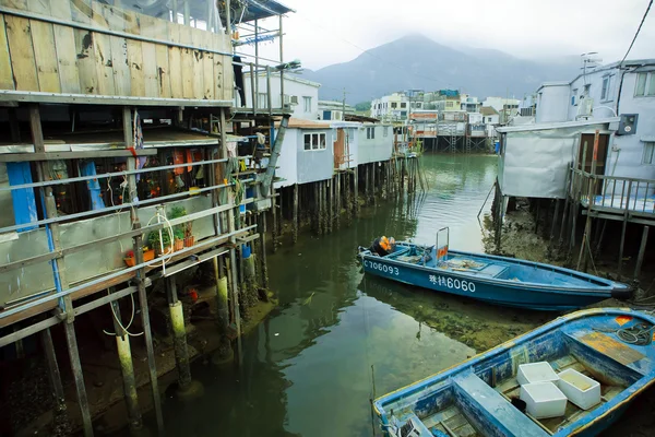 Lanchas fluviales de pescadores cerca de casas de metal sobre pilotes de madera en pueblo pobre — Foto de Stock