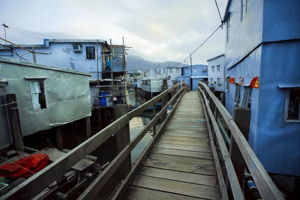 Casas rústicas abandonadas de metal del pueblo de pescadores con puente de madera Imágenes De Stock Sin Royalties Gratis