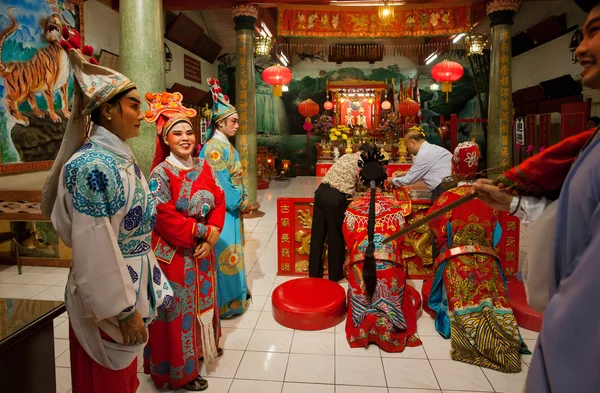 Actores inventados de ópera china en trajes vintage rezando dentro de colorido templo budista en estilo antiguo — Foto de Stock