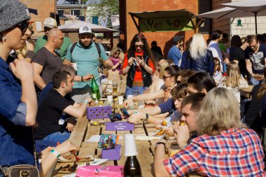 Many people drinking beer and eating food during outdoor Street Food Festival