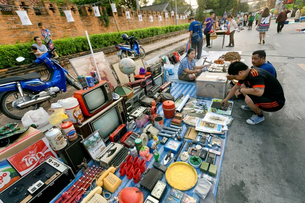 Pessoas fazendo escolha no mercado de segunda mão ao ar livre com rádio, televisores e outros bens — Fotografia de Stock