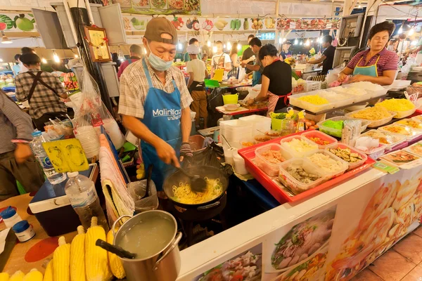 Fast-food vendeur cuisine à un marché de nuit différents repas avec des fruits de mer et des légumes frais — Photo