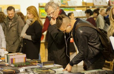 Men of different generations reading books of the International Book Festival
