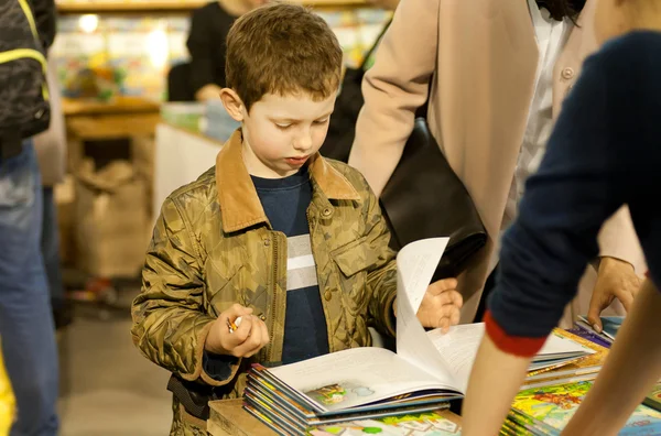 Невідомі маленького хлопчика читання барвисті книг у дітей області книжкового фестивалю — стокове фото