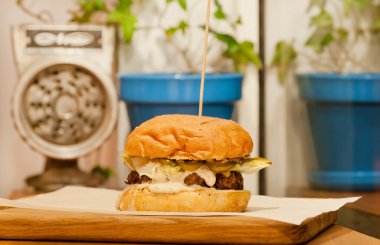 Selective focus on small burger with fresh vegetables, meat and bun.