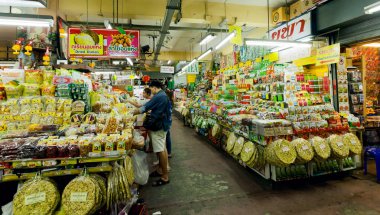 Customers buying exotic products at big market with spices, meat, fresh vegetables and sweets