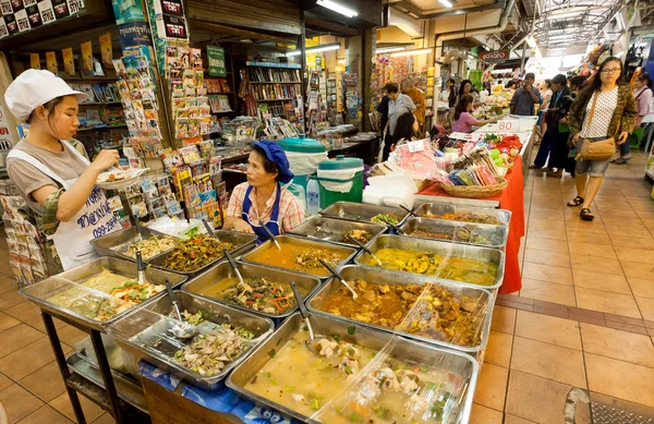 Women sell asian fast-food with meat inside the market with delicacies and farming products — Zdjęcie stockowe