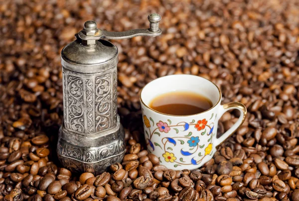 Natureza morta de grãos de café e moedor de café com copo de café de estilo oriental — Fotografia de Stock