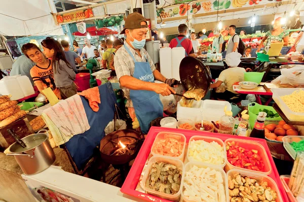 Φαστ-φουντ προμηθευτή μαγείρεμα σε μια αγορά νύχτα διαφορετικά γεύματα με θαλασσινά και φρέσκα λαχανικά — Φωτογραφία Αρχείου