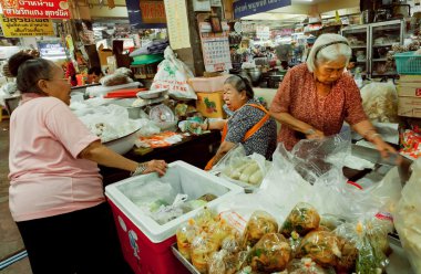 Kadınlar büyük markette baharat, fasulye, taze sebze ve egzotik yiyeceklerle alışveriş yapıyorlar.