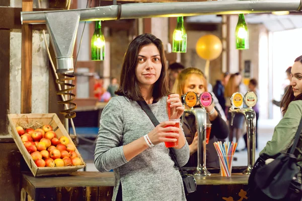 Joven mujer feliz comprando vaso de sidra sabrosa en el bar de —  Fotos de Stock