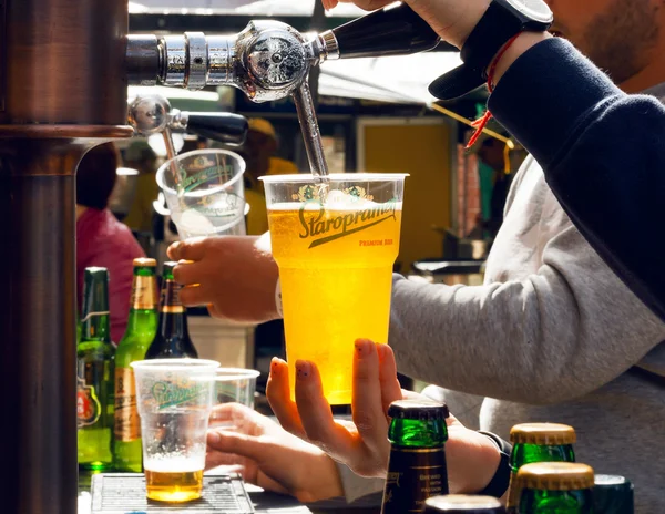 Bartender derrama cerveja em vidro plástico durante Street Food Festival — Fotografia de Stock