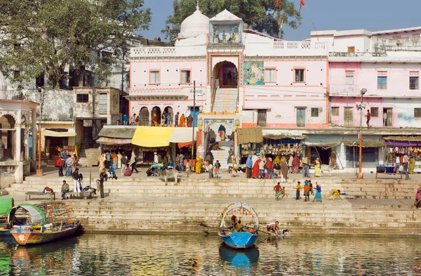 Vecchi edifici della città indiana sul fiume con la folla di persone fuori — Foto Stock