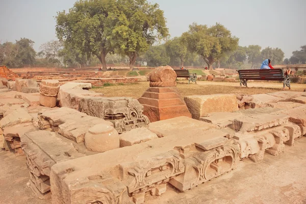 Zerstörte buddhistische Tempelmauern in grünem Park mit indischen Touristen — Stockfoto