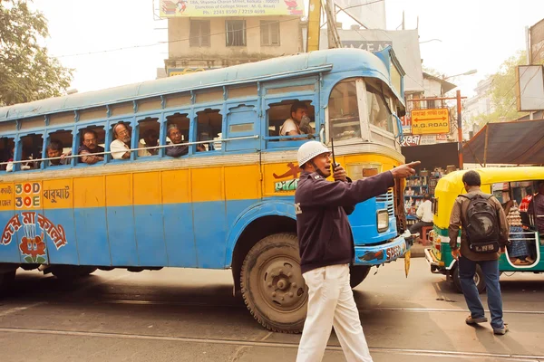 Policier du service de la route essayant de diriger la circulation dans une rue avec des bus et des personnes à pied — Photo
