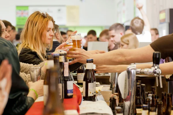 Personas bebiendo y comprando cerveza de nuevo en multitud de clientes — Foto de Stock