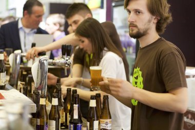 Barmen zanaat dokunun bira meşgul barda içki alıyor.