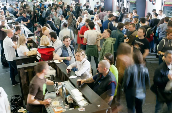 Beaucoup de gens dégustant des sortes de bière dans l'immense hall du bar — Photo