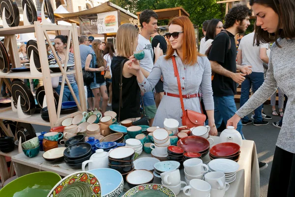 Jonge vrouwen kiezen aardewerk op de stand van overvolle weekend straat — Stockfoto