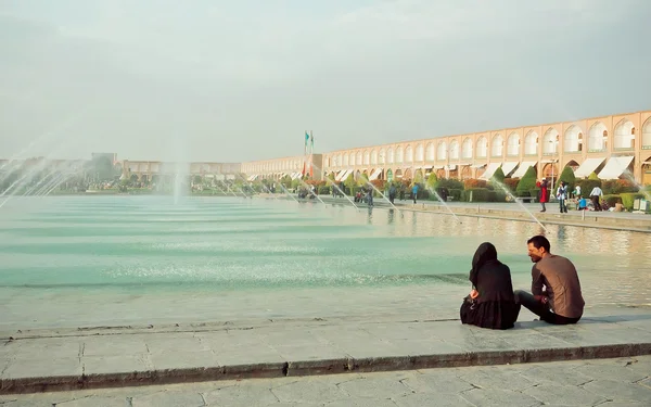 若いカップル、イスファハンのイマーム広場の噴水の近くの話 — ストック写真