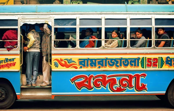 Colorful bus driving on indian street and many different people inside of it — Stock Photo, Image