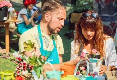 Genç çift üzerinde açık Fuar Çiçek demetleri yapmak öğrenir