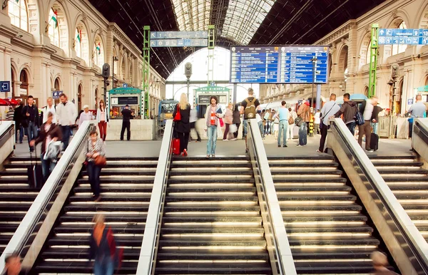 Rushing people inside the structure of Keleti railway station with trains on platform — Stock Photo, Image