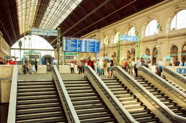 Stairs and metal ceilings of railway station with crowd of passengers — Stock Photo, Image