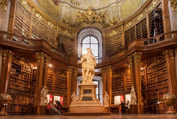 Antique sculpture in interior of old books of the Austrian National Library — Stock Photo, Image